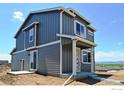 Gray two-story house with white trim, a small deck, and mountain views at 521 Hillsview Dr, Berthoud, CO 80513