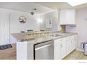 Kitchen boasts a breakfast bar, stainless steel dishwasher and white cabinets at 7880 W 87Th Dr # C, Arvada, CO 80005