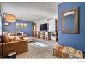 Living room featuring built-in shelving and a large flat-screen TV at 8267 Quay Ct, Arvada, CO 80003