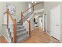 Elegant staircase with hardwood flooring and a gray carpet runner at 839 W Mahogany Cir, Louisville, CO 80027