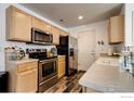 Kitchen with stainless steel appliances and light wood cabinets at 10685 Forester Pl, Longmont, CO 80504