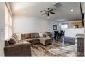 Spacious living room with L-shaped sectional sofa and hardwood floors at 10685 Forester Pl, Longmont, CO 80504