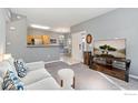 Living room with a sofa, TV, and view into the kitchen at 1138 Opal St # 101, Broomfield, CO 80020