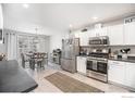 Modern kitchen featuring stainless steel appliances and white cabinetry at 11661 Kearney Way, Thornton, CO 80233