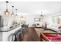 Open concept living area with a kitchen island, hardwood floors, and modern lighting at 1382 Glen Ct, Boulder, CO 80305