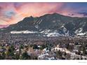 Aerial view of houses in snowy neighborhood with mountains in background at 1465 Periwinkle Dr, Boulder, CO 80304