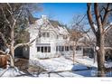 Two-story white house with snowy front yard and mature trees at 1465 Periwinkle Dr, Boulder, CO 80304