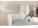 Living room with carpeted floors, stairs, and neutral wall colors at 1580 Venice Ln, Longmont, CO 80503