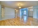 Bright living room with hardwood floors, light blue walls, and a staircase at 241 Sherwood Ct, Longmont, CO 80504