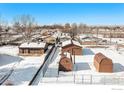 Aerial view showing house and multiple sheds in a snow covered yard at 245 Cedar St, Hudson, CO 80642