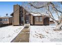 Cozy ranch home exterior with wood siding and stone accents, snowy yard at 245 Cedar St, Hudson, CO 80642