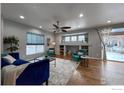 Open living room featuring hardwood floors, a ceiling fan, and access to the backyard at 4329 San Marco Dr, Longmont, CO 80503