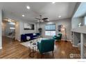 Spacious living room featuring hardwood floors, a ceiling fan, and teal armchairs at 4329 San Marco Dr, Longmont, CO 80503