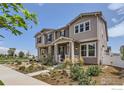 Two-story townhome with gray siding, front porch, and nicely landscaped yard at 462 Canadian Crossing Dr, Longmont, CO 80504