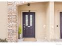 Dark brown front door with glass panels and stone column at 1011 Sonoma Cir # D, Longmont, CO 80504