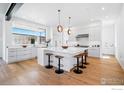 Spacious kitchen with white cabinetry, large island with seating, and modern pendant lights at 2125 Vine Ave, Boulder, CO 80304
