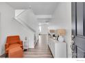 Bright entryway with an orange armchair, storage console, and stairs at 3178 Beaumont Blvd, Mead, CO 80542