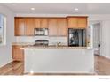 Modern kitchen with wood cabinets, stainless steel appliances, and a breakfast bar for casual dining at 6508 Copper Dr, Frederick, CO 80516