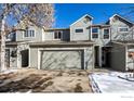 Two-story townhome with attached garage and snow-covered landscaping at 11277 Holly St, Thornton, CO 80233