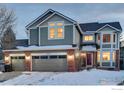 Two-story home with gray siding, brick accents, and attached garage at 1452 Cherrywood Way, Longmont, CO 80504