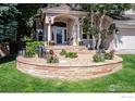 Landscaped front yard with stone retaining wall and colorful plants at 1825 Vernon Ln, Superior, CO 80027