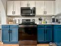 Stylish kitchen featuring teal cabinets, stainless steel appliances, and white quartz countertops at 2010 E 99Th Pl, Thornton, CO 80229