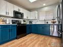 Modern kitchen with teal cabinets, stainless steel appliances, and white countertops at 2010 E 99Th Pl, Thornton, CO 80229