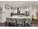 Bright kitchen with stainless steel appliances, large island, and modern backsplash at 21463 E 59Th Pl, Aurora, CO 80019