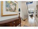 Elegant entryway with hardwood floors, a console table, and a view of the staircase at 3364 Danzante Bay Ct, Berthoud, CO 80513