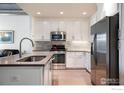 Modern kitchen with white cabinets, stainless steel appliances, and an island at 3401 Arapahoe Ave # 105, Boulder, CO 80303