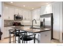 Modern kitchen with white cabinets, stainless steel appliances, and an island at 3401 Arapahoe Ave # 105, Boulder, CO 80303