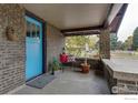 Charming front porch with a bright blue door and welcoming seating at 402 11Th N Ave, Longmont, CO 80501