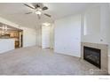 Bright and open living area with a fireplace, neutral tones, and a ceiling fan at 5756 N Genoa Way # 205, Aurora, CO 80019