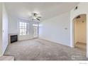 Bright living room showcasing a fireplace, ceiling fan, neutral paint, and glass door at 5756 N Genoa Way # 205, Aurora, CO 80019