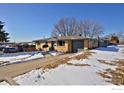 Brick ranch home with a driveway and snowy yard at 6487 Eaton St, Arvada, CO 80003