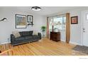 Bright living room featuring hardwood floors and a gray sofa at 6487 Eaton St, Arvada, CO 80003