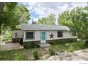 White ranch home with teal door, stone accents, and landscaping at 6903 Valmont Rd, Boulder, CO 80301