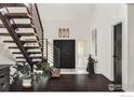 Modern entryway with rustic wooden staircase and dark hardwood floors at 7035 Rustic Trl, Boulder, CO 80301