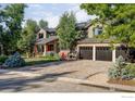 House exterior showcasing landscaping and a paved driveway at 7035 Rustic Trl, Boulder, CO 80301