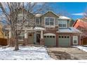 Charming two-story home with a brick facade, two-car garage, and snow-covered front yard at 811 Vireo Ct, Longmont, CO 80504