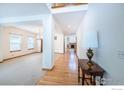 Bright foyer with hardwood floors leading to a living room with carpet and views of a fireplace at 811 Vireo Ct, Longmont, CO 80504