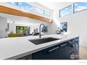 Kitchen island with sink, modern faucet, and a view into the living area at 836 Walnut St # E, Boulder, CO 80302