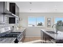 Modern kitchen with granite countertops, stainless steel appliances, and mountain views at 8393 Stoneridge Ter, Boulder, CO 80302