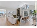 Bright living room features a cozy fireplace and access to a deck with scenic views at 8393 Stoneridge Ter, Boulder, CO 80302