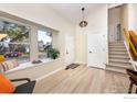 Inviting foyer with light hardwood floors, a window seat, and a staircase leading to the upper level at 10579 Cherry St, Thornton, CO 80233