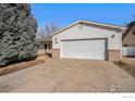 Exterior view of the home and driveway leading to attached two-car garage at 1130 Navajo Pl, Berthoud, CO 80513