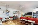 Living room with hardwood floors, red couch, and stylish light fixtures at 1148 Gay St, Longmont, CO 80501