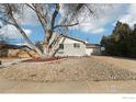 Gray ranch house with a mature tree in the front yard and gravel landscaping at 1310 Toedtli Dr, Boulder, CO 80305