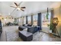 Bright living room with a large sectional sofa, tiled floors, and large windows at 1373 E 110Th Pl, Northglenn, CO 80233