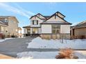 Two-story house with white siding, dark garage door, and stone accents at 16636 W 94Th Dr, Arvada, CO 80007